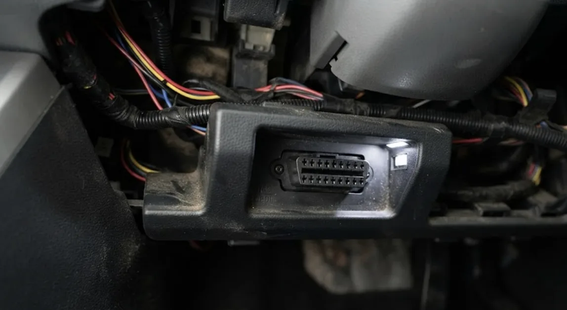 Connecteur de diagnostic OBD2 à 16 broches situé sous le tableau de bord d'une Fiat 500